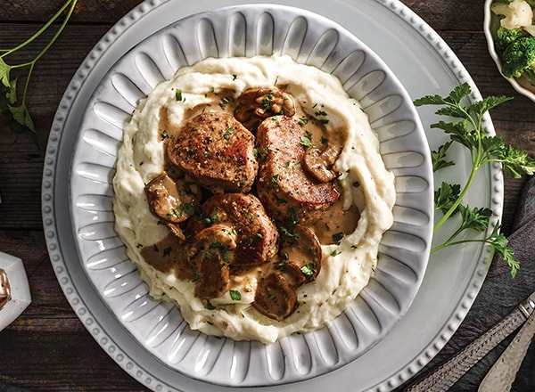 Pork with Mushrooms and Brie Sauce Over Mashed Potatoes