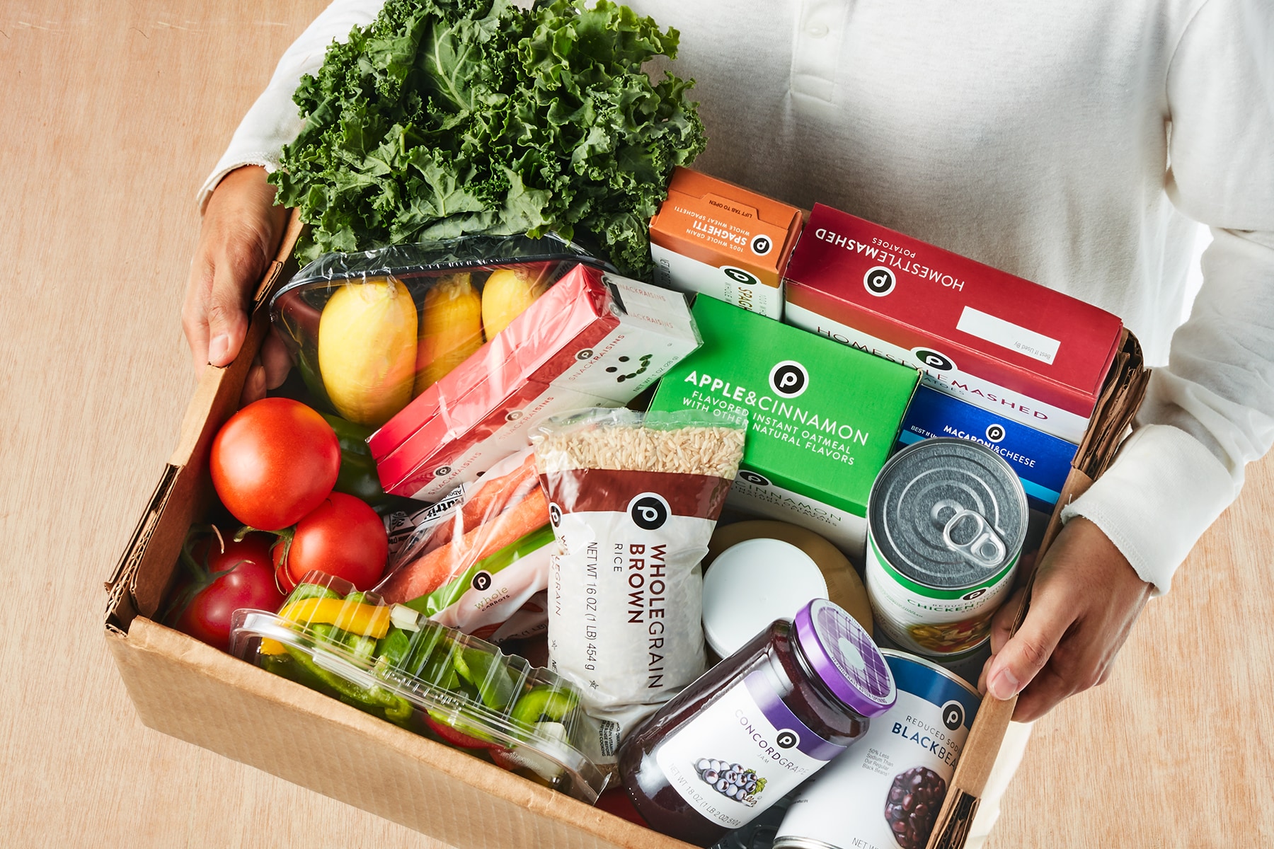 hands hold box of Publix groceries 