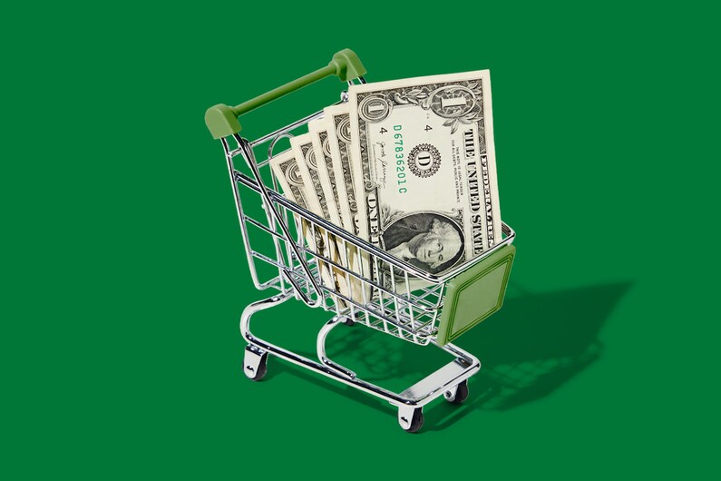 mini shopping cart with dollar bills inside 