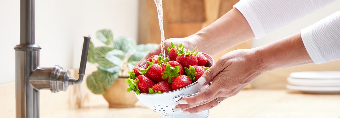 hands washing strawberries 