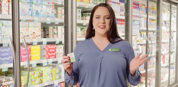 women holding a better choice shelf tag in a grocery store aisle 