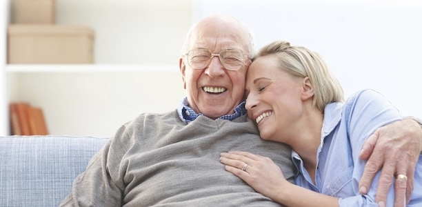 man and woman laughing on the couch together 