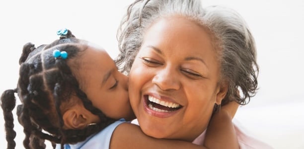 granddaughter kissing grandmother on the cheek  