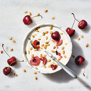 bowl of yogurt with fresh cherries