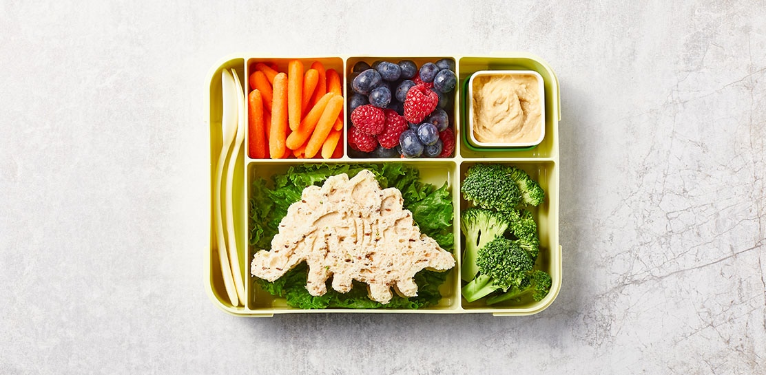 bento box with a dino shaped sandwich