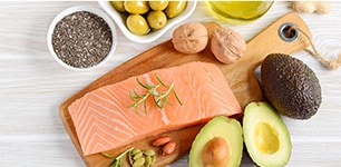 display of raw salmon, avocado, olives, nuts and olive oil