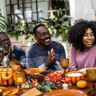 happy family gathered around a thanksgiving dinner table