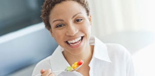 woman eating bowl of fruit