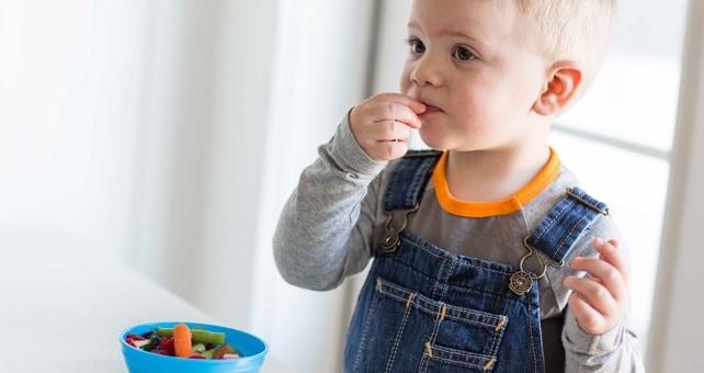 little boy eating vegetables
