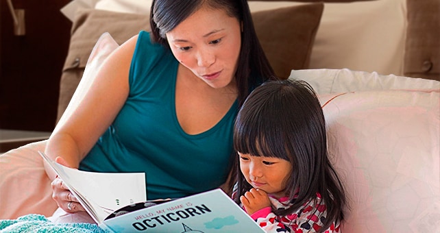 mother reading to daughter in bed