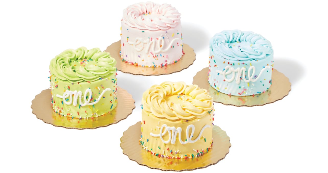 four small pastel cakes with one written on the side 