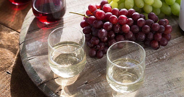 wine glasses on a table with grapes