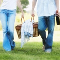 two people carrying a picnic basket