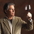 man looking at wine in a glass