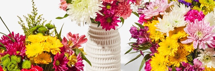 three colorful bouquets of flowers in vases 