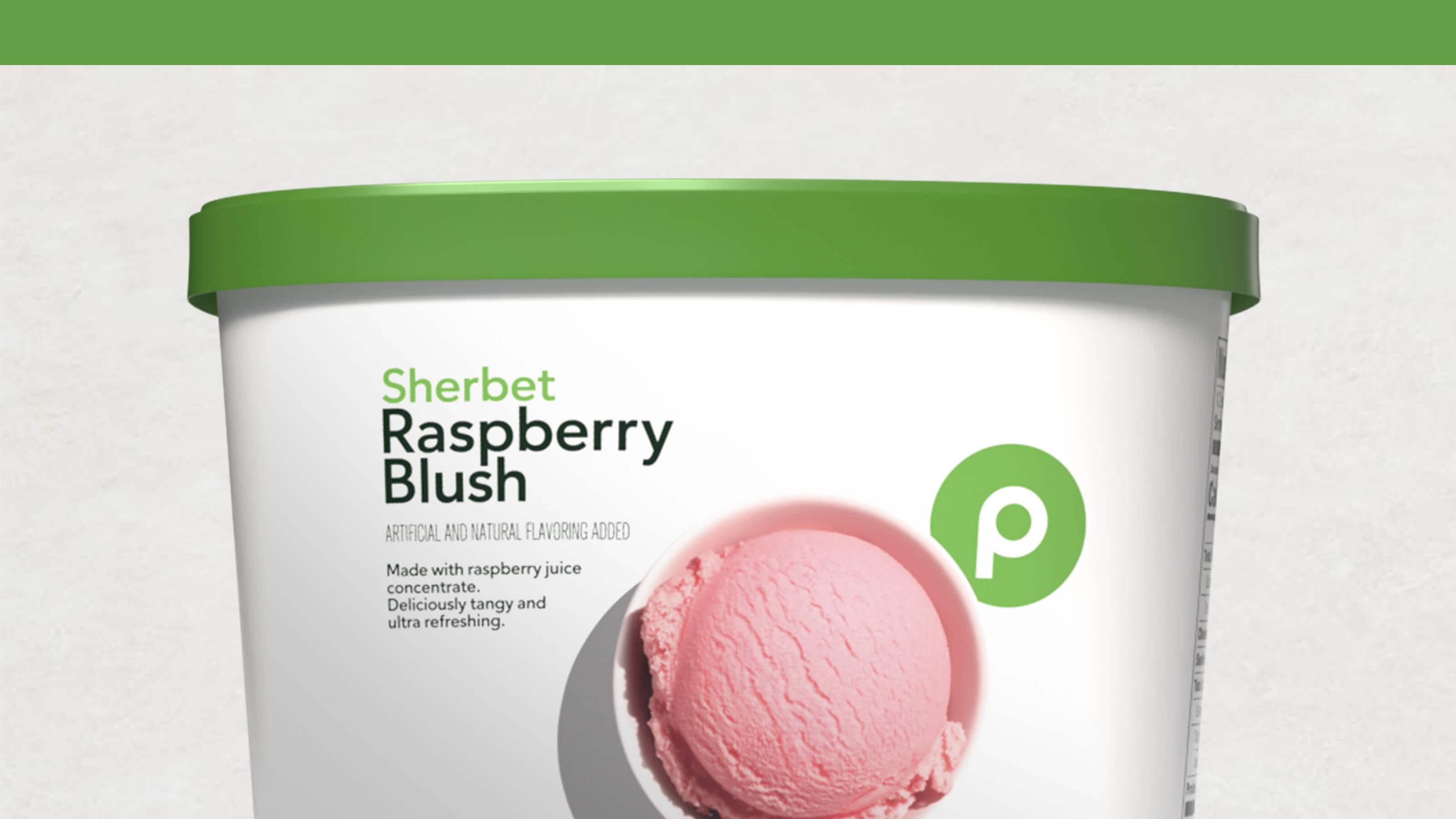 A tub of Publix Raspberry Blush Sherbet with a green lid, featuring a scoop of pink sherbet on the packaging.