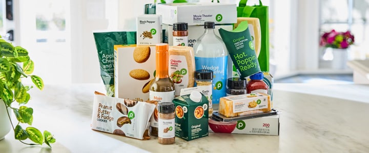 Kitchen countertop filled with bags of Publix groceries 