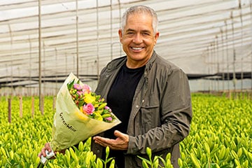 grower holding fresh flowers in a greenhouse