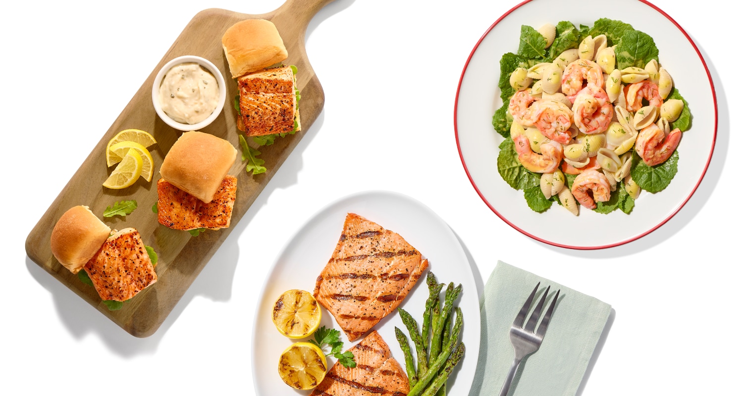 Grilled salmon sliders with sauce and lemon slices, grilled salmon with asparagus, and shrimp pasta salad on a white background.