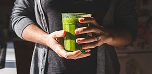 hands holding glass of smoothie drink