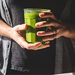 hands holding glass of smoothie drink