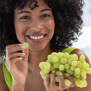 Woman holding green grapes