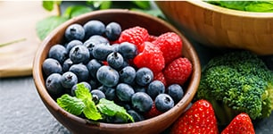 bowl of blueberries and raspberries with mint leaves
