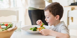 Boy eating veggies