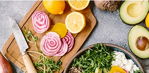 cutting board with lemons, onions, and herbs