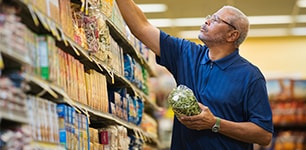 man selecting items from grocery shelf