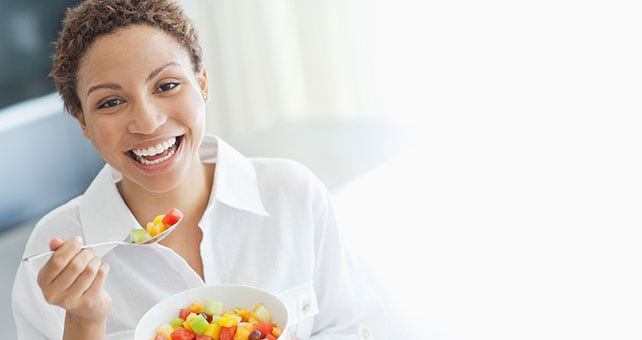 woman eating bowl of fruit