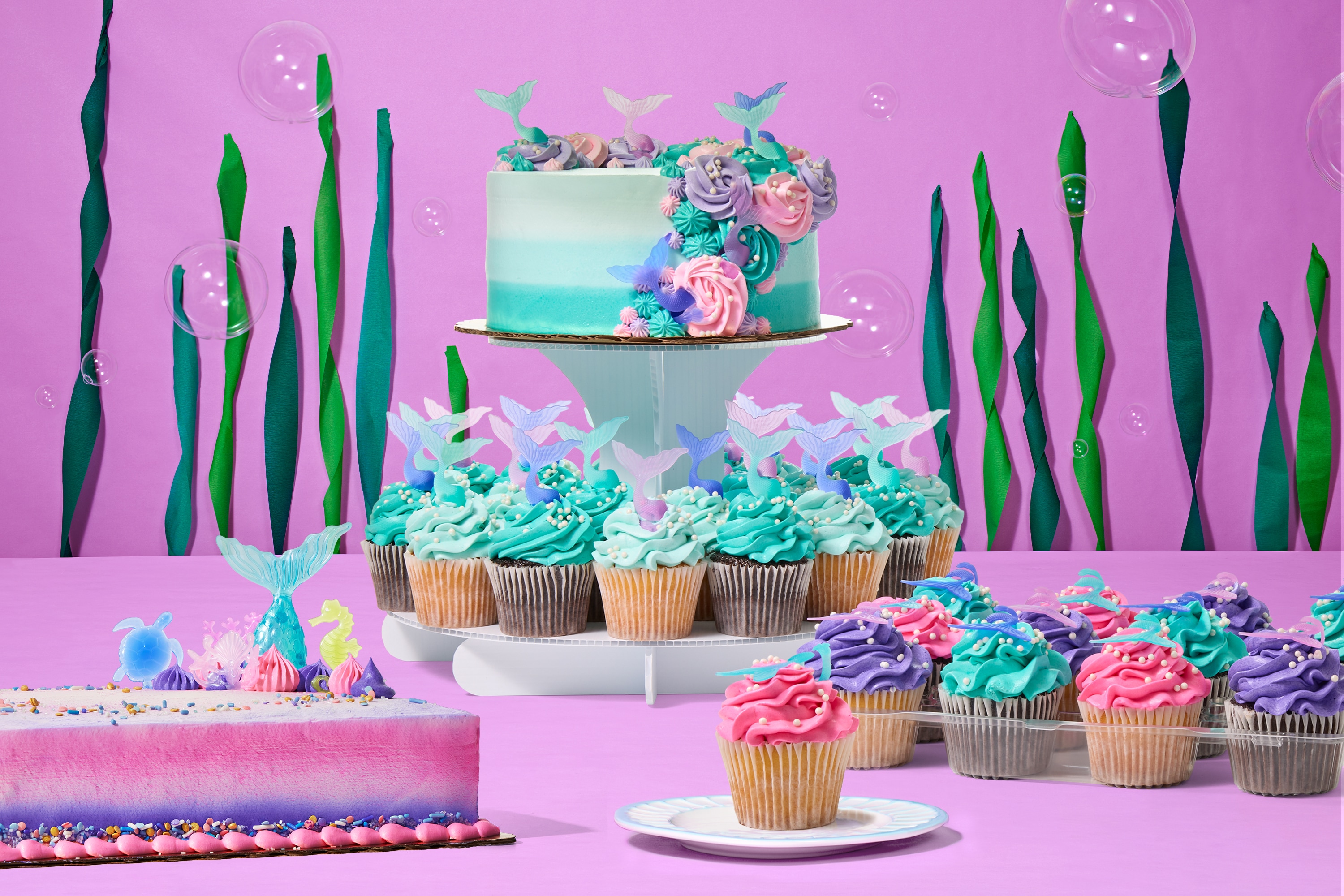Mermaid-themed cakes and cupcakes from Publix with pastel ocean colors, seashells, and shimmering accents, available for online order and pickup in Florida.